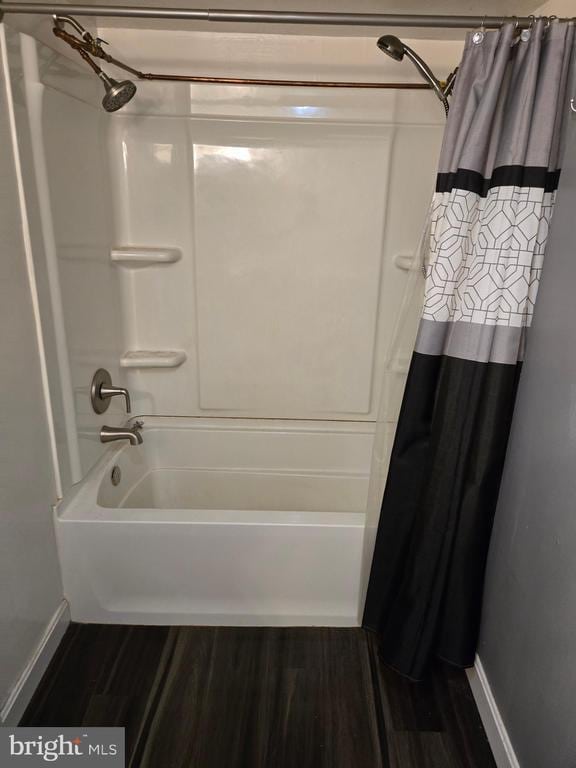  - bathroom featuring shower / bath combo and wood finished floors