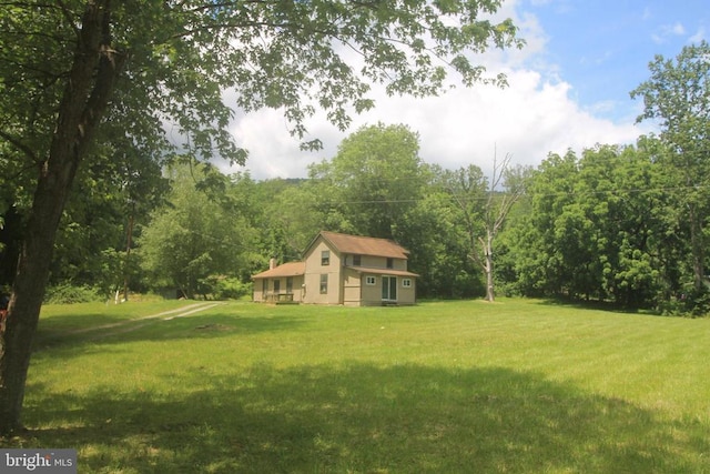  - view of grassy yard with a wooded view