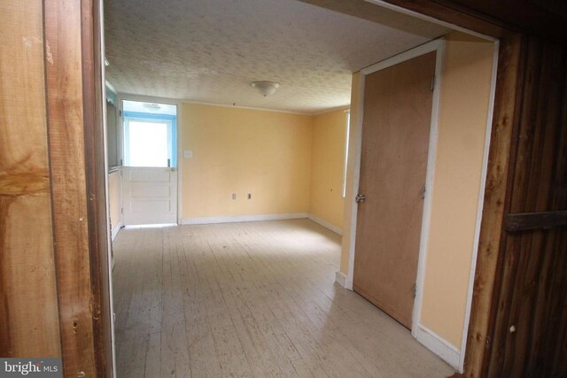  - hallway featuring light wood-style flooring and a textured ceiling