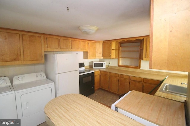  - kitchen with white appliances, washing machine and dryer, and brown cabinets