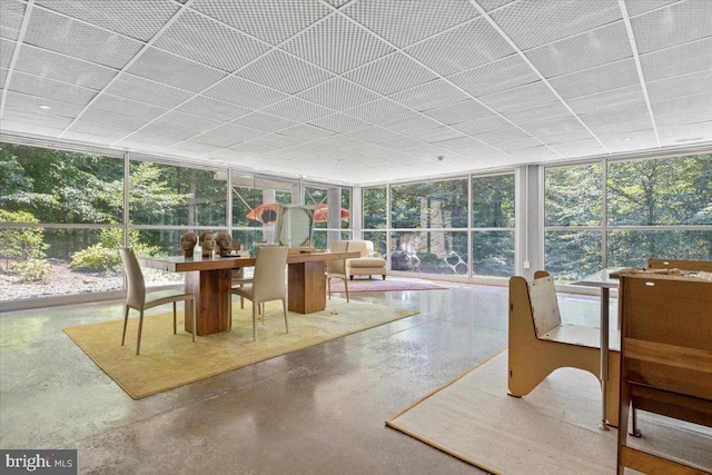  - sunroom featuring expansive windows, finished concrete floors, and a paneled ceiling