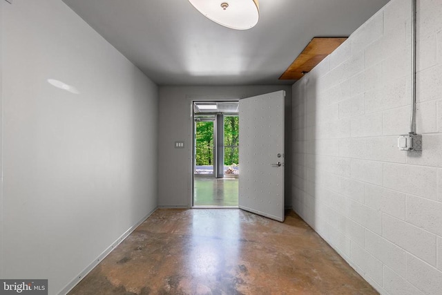 interior space featuring concrete block wall and concrete flooring
