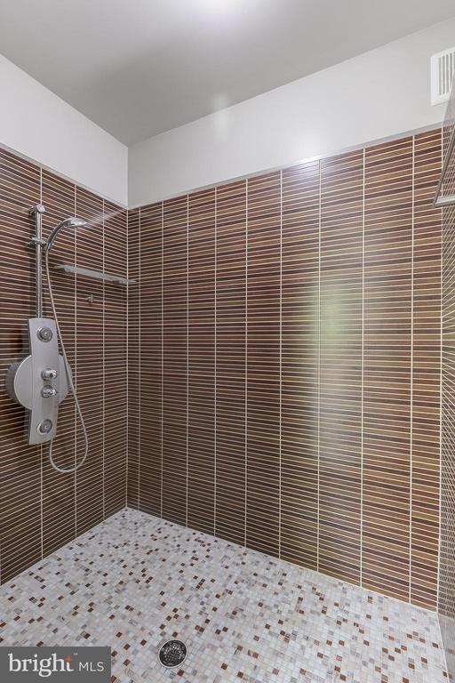 full bathroom featuring visible vents and tiled shower