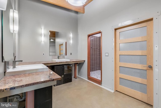 bathroom with finished concrete flooring, a heating unit, and a sink