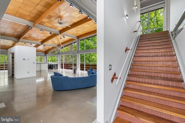 staircase with wood ceiling, vaulted ceiling with beams, concrete flooring, baseboards, and ceiling fan