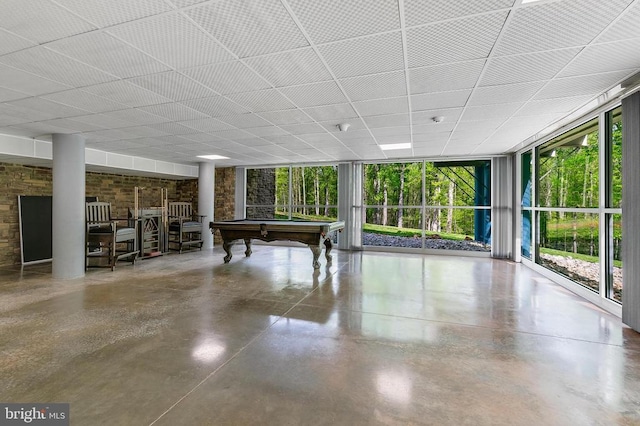 rec room with concrete floors, billiards, and floor to ceiling windows