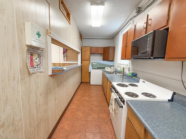 1203 Windsor Ln, Staunton, VA 24401 - kitchen with electric stove, black microwave, wooden walls, brown cabinets, and light tile patterned floors