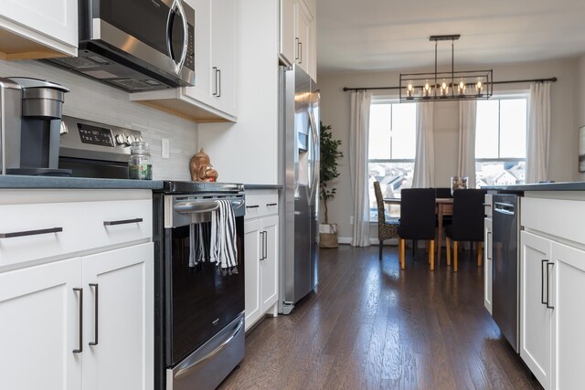3381 Monterey Dr, Rockingham, VA 22801 - kitchen with stainless steel appliances, dark wood finished floors, tasteful backsplash, and white cabinetry