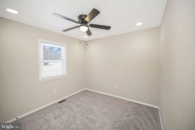 unfurnished room featuring ceiling fan and light carpet