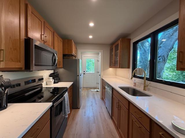 1201 Lakeshore Dr S, Louisa, VA 23093 - kitchen with appliances with stainless steel finishes, a sink, light wood finished floors, brown cabinetry, and light countertops