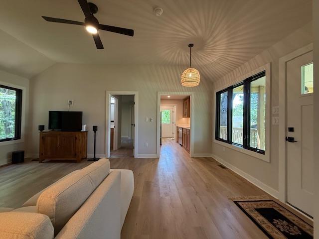 1201 Lakeshore Dr S, Louisa, VA 23093 - living room with healthy amount of natural light, light wood finished floors, lofted ceiling, baseboards, and ceiling fan
