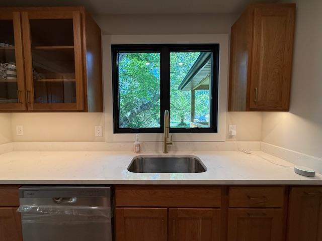 1201 Lakeshore Dr S, Louisa, VA 23093 - kitchen featuring stainless steel dishwasher, a sink, light countertops, glass insert cabinets, and brown cabinetry