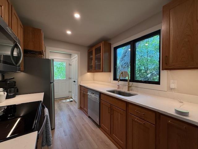 1201 Lakeshore Dr S, Louisa, VA 23093 - kitchen with a sink, stainless steel dishwasher, electric range oven, light wood-style floors, and glass insert cabinets