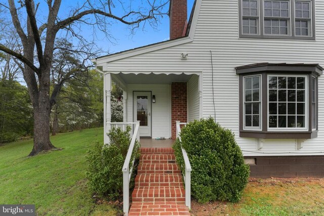 412 Nelmonte Ln, Arrington, VA 22922 - view of exterior entry with a lawn, a chimney, and covered porch