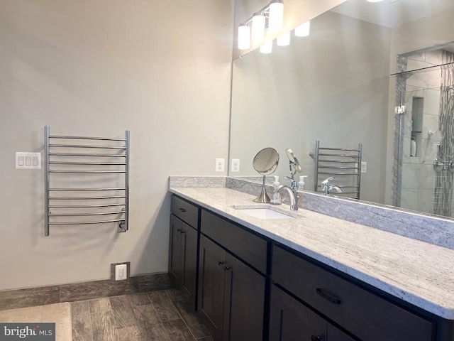  - bathroom featuring a shower stall, baseboards, radiator heating unit, and vanity
