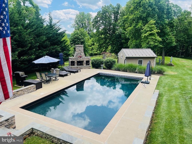  - outdoor pool featuring a lawn, an outbuilding, an outdoor stone fireplace, and a patio