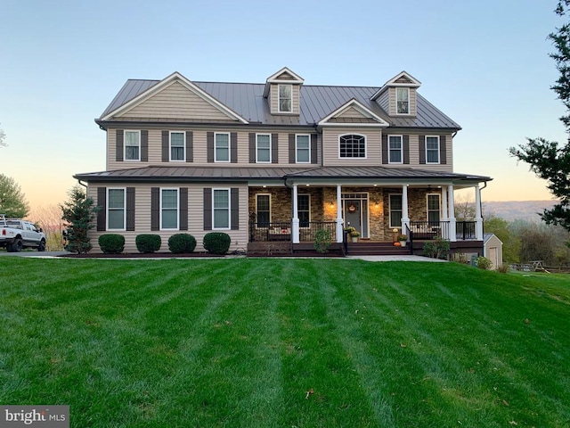 - view of front facade with metal roof, a standing seam roof, and a front lawn