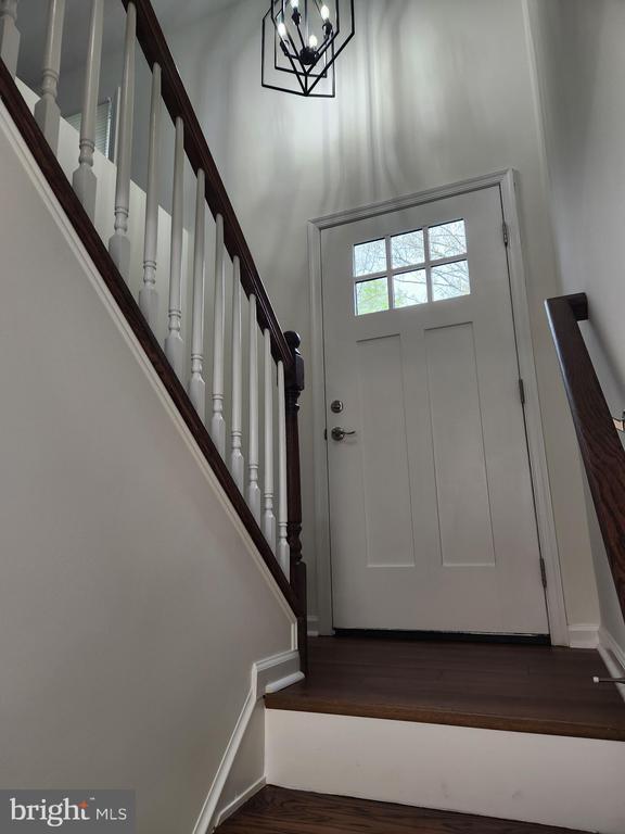 10703 Redbird Ln, Spotsylvania, VA 22553 - entrance foyer featuring stairs, dark wood-style floors, a chandelier, and a high ceiling