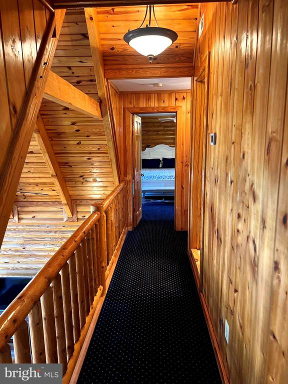 26536 Pennfields Dr, Orange, VA 22960 - hall with wood walls, carpet floors, and wooden ceiling