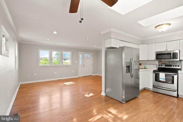 6314 Foster Rd, Spotsylvania, VA 22553 - kitchen featuring appliances with stainless steel finishes, a ceiling fan, light wood-style flooring, white cabinetry, and crown molding