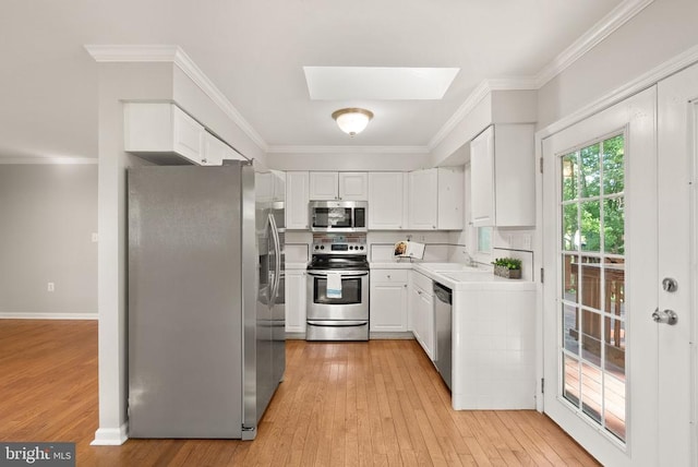 6314 Foster Rd, Spotsylvania, VA 22553 - kitchen featuring appliances with stainless steel finishes, light wood-style floors, light countertops, crown molding, and white cabinets