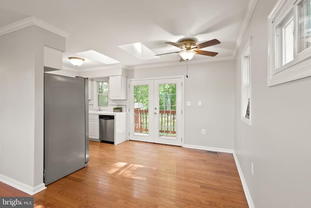 6314 Foster Rd, Spotsylvania, VA 22553 - kitchen with appliances with stainless steel finishes, a skylight, ceiling fan, light wood-type flooring, and white cabinets