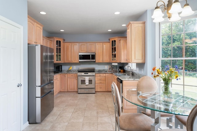 31 Hampton Dr, Stuarts Draft, VA 24477 - kitchen featuring stainless steel appliances, light stone counters, a chandelier, light brown cabinets, and glass insert cabinets