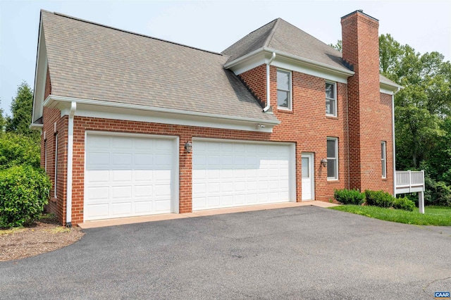 1460 Brentwood Way, Earlysville, VA 22936 - view of side of property with a chimney, brick siding, a shingled roof, and asphalt driveway