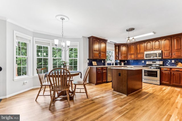 3803 Fallwood Ln, Fredericksburg, VA 22408 - kitchen featuring stainless steel appliances, a sink, a chandelier, ornamental molding, and decorative backsplash