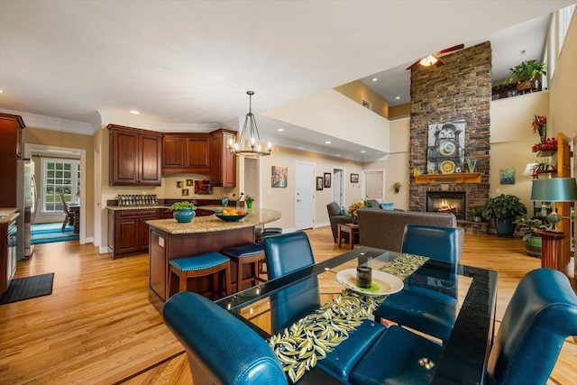 515 Legrande Ave, Waynesboro, VA 22980 - dining area with light wood-style floors, a stone fireplace, recessed lighting, a chandelier, and crown molding