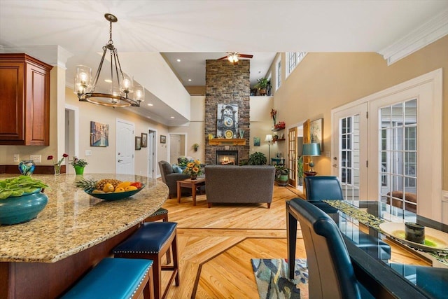 515 Legrande Ave, Waynesboro, VA 22980 - dining area with a chandelier, a towering ceiling, a fireplace, ornamental molding, and light wood-style flooring