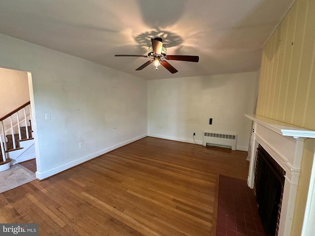 2 Terrace Ln, Luray, VA 22835 - unfurnished living room with radiator, a ceiling fan, wood finished floors, and a fireplace with flush hearth