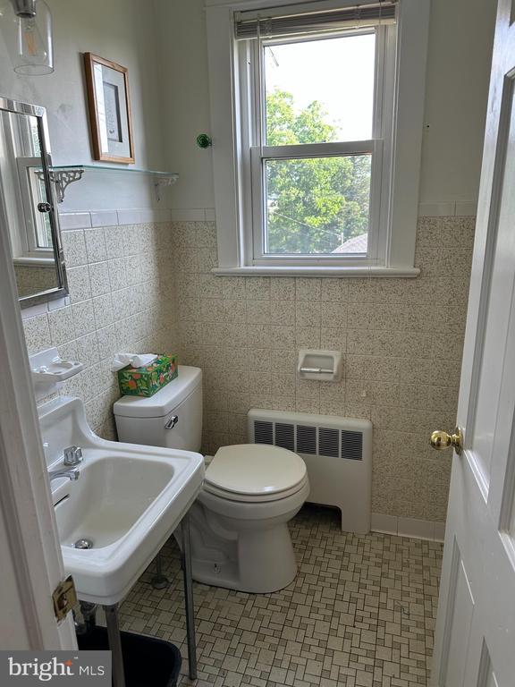 2 Terrace Ln, Luray, VA 22835 - bathroom featuring radiator, tile walls, and wainscoting