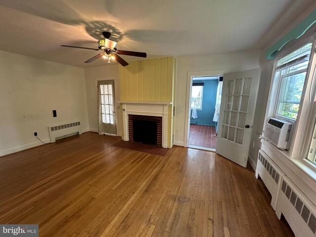 2 Terrace Ln, Luray, VA 22835 - unfurnished living room with radiator heating unit, hardwood / wood-style flooring, a fireplace, and a ceiling fan