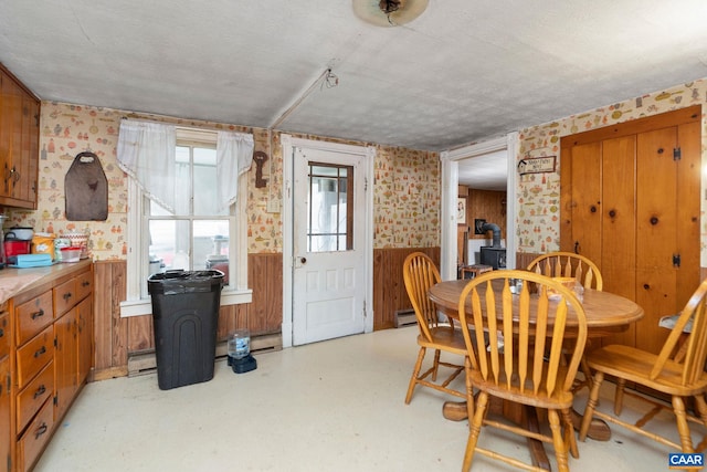 613 6th St, Shenandoah, VA 22849 - dining space with wallpapered walls, a wainscoted wall, a textured ceiling, light flooring, and wooden walls