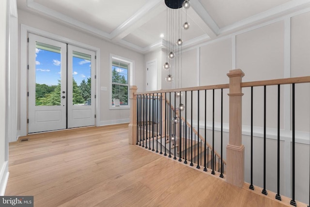  - hallway with an upstairs landing, wood finished floors, beamed ceiling, coffered ceiling, and ornamental molding