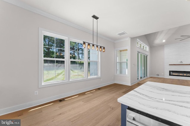  - dining room with light wood-type flooring, ornamental molding, and a fireplace