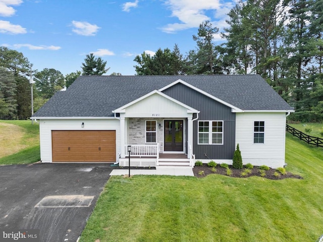  - view of front facade with covered porch, a garage, roof with shingles, driveway, and french doors