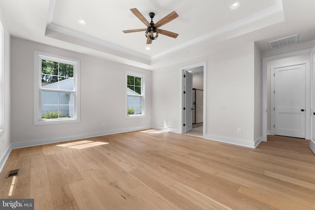  - unfurnished bedroom with a tray ceiling, light wood-style floors, and recessed lighting