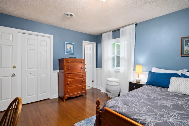 1233 Pinehurst Rd, Staunton, VA 24401 - bedroom with dark wood finished floors, a textured ceiling, a closet, and a wainscoted wall