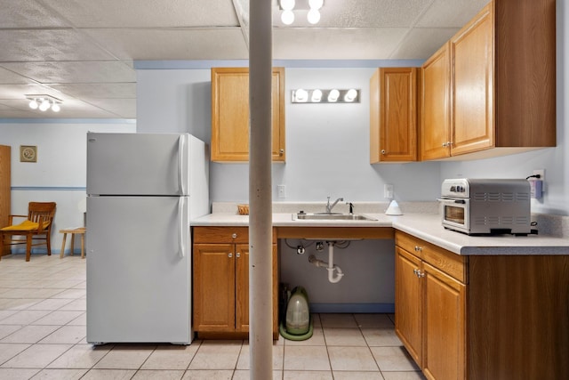 1233 Pinehurst Rd, Staunton, VA 24401 - kitchen with freestanding refrigerator, light tile patterned floors, light countertops, a paneled ceiling, and brown cabinets
