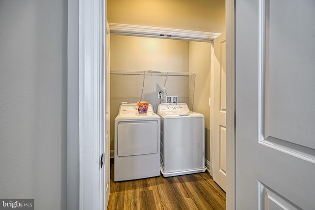 clothes washing area featuring separate washer and dryer and dark wood-style flooring