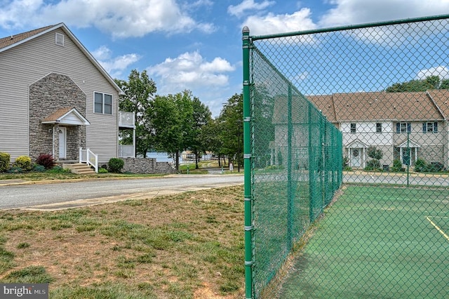 view of tennis court featuring fence and a gate