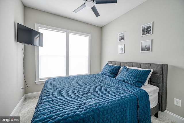 carpeted bedroom featuring multiple windows, baseboards, and a ceiling fan