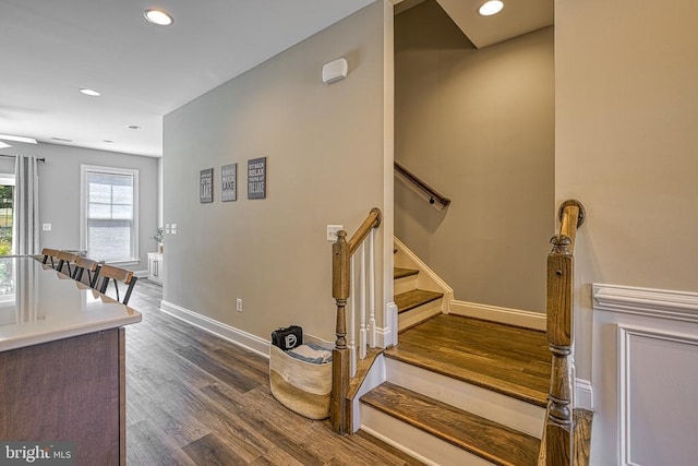 stairway with wood finished floors, recessed lighting, and baseboards