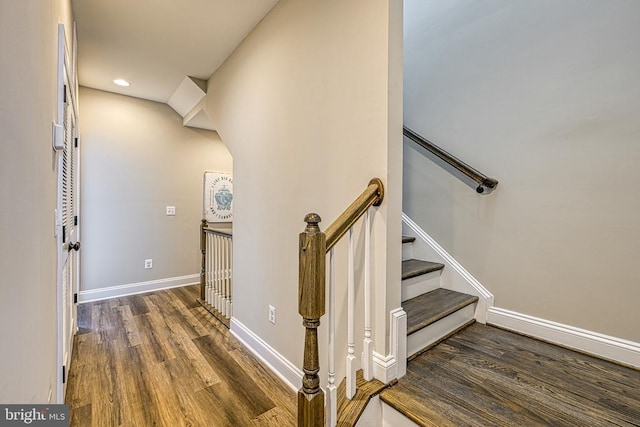 staircase featuring wood finished floors, baseboards, and recessed lighting