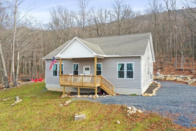 115 Mountain Top Ln, New Market, VA 22844 - view of front of house featuring a deck, a wooded view, a shingled roof, and a front yard