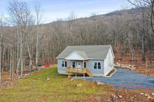 115 Mountain Top Ln, New Market, VA 22844 - view of front of home with covered porch, a wooded view, roof with shingles, and a front yard