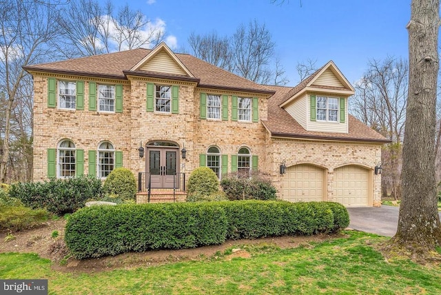  - colonial-style house with french doors, a garage, asphalt driveway, brick siding, and a shingled roof