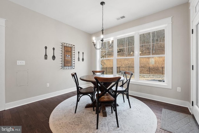  - dining room featuring a chandelier and dark wood-style flooring